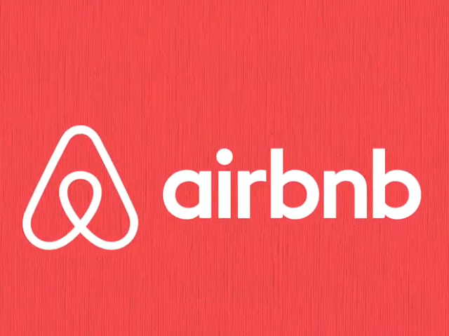 Airbnb logo with white text and symbol on a bright red background