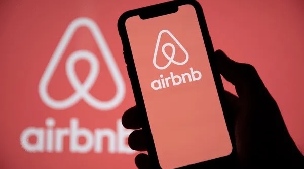 Hand holding smartphone with Airbnb app