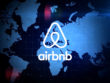 Airbnb logo illuminated over a global map with a celestial blue background
