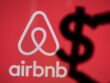 Hand holding dollar icon on background of Airbnb logo