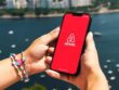 Hand holding smartphone with Airbnb app